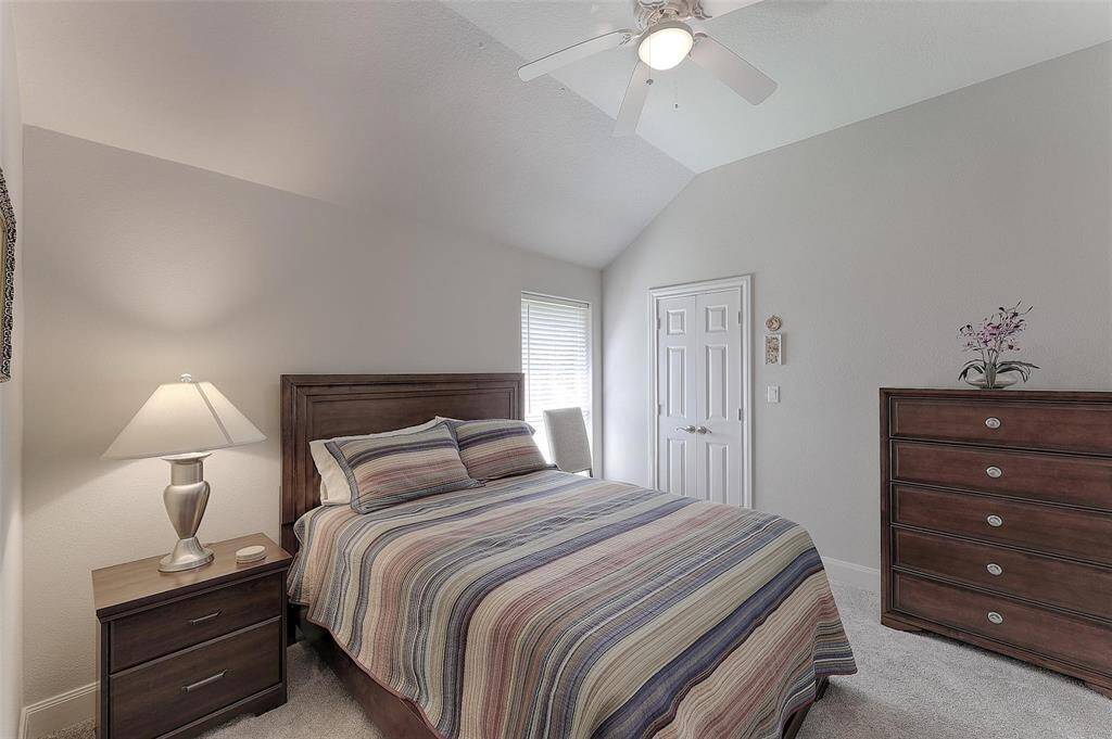 A third guest bedroom is also bright and features neutral paint with carpet and high ceilings.