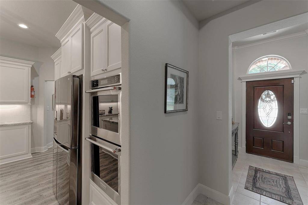 Proximity of kitchen from the entry. Notice the custom trim around the front door and arched window.