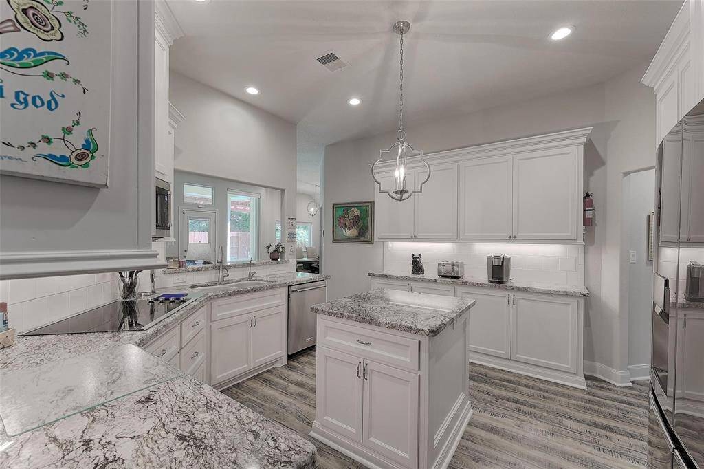 Updated kitchen features granite counters, center island with storage, updated lighting including under counter lighting and stainless steel appliances.
