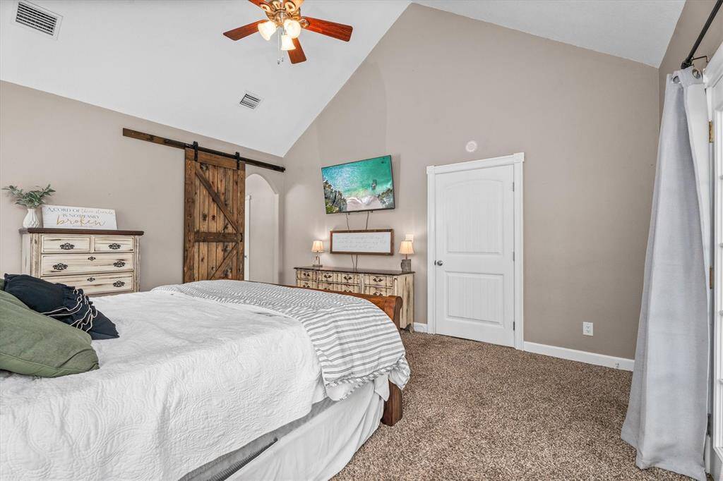Primary bedroom with barn door leading to bathroom