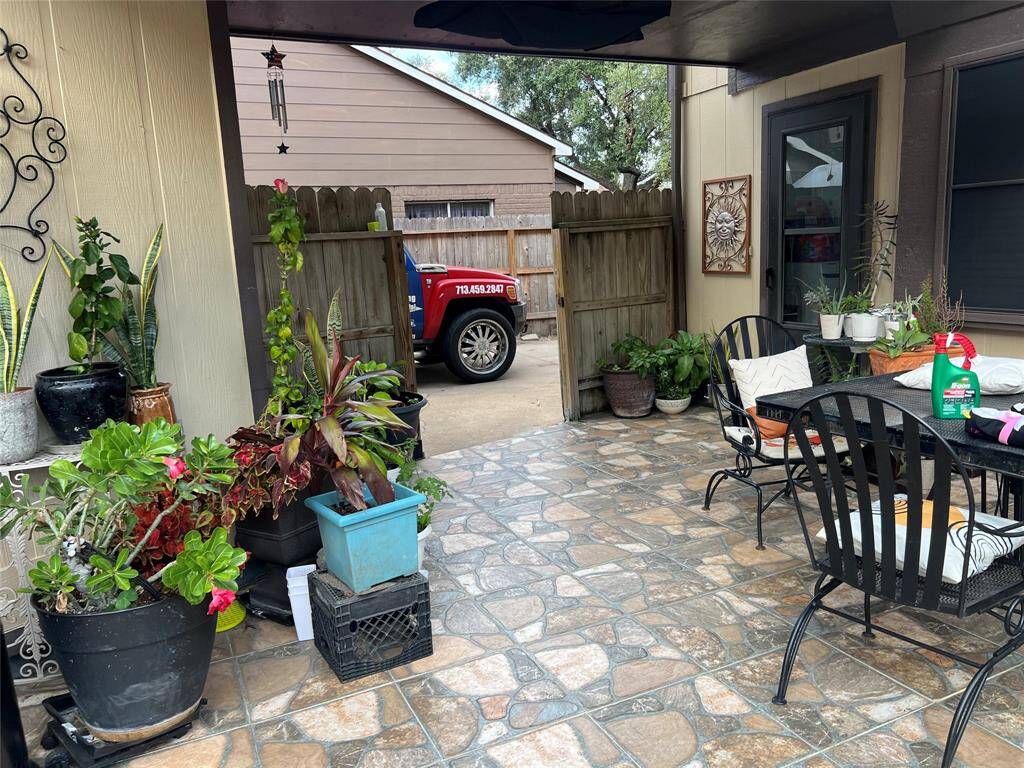 Spacious backyard with a grass lawn, featuring a swing set under a pergola, a small shed, and a two-story structure with a balcony. Perfect for outdoor activities and relaxation.