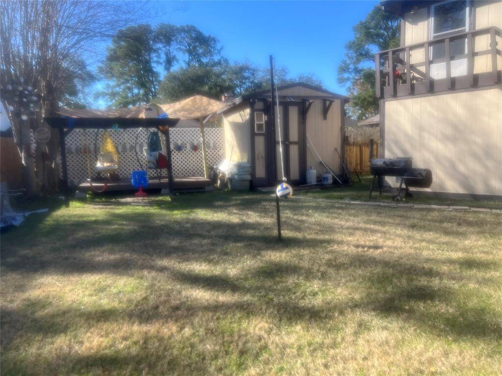 Discover your perfect outdoor retreat with this sunny backyard featuring a lush lawn and a charming two-story home. Enjoy seamless access to the upper level via an exterior staircase, and entertain on the cozy patio complete with a portable grill. A convenient storage shed completes this inviting space.