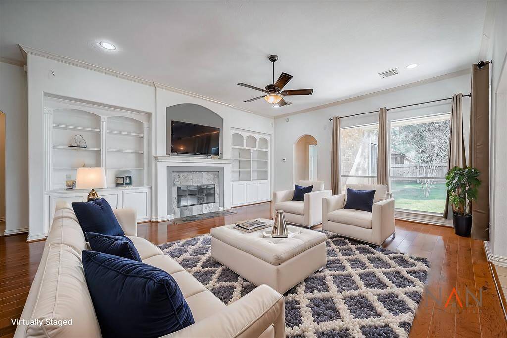 Make yourself at home in this warm and welcoming family room. With its charming built-ins and inviting fireplace, it’s the perfect spot to curl up with a good book or gather with loved ones. Sunlight pours in through the large windows, offering a lovely view of the backyard and filling the space with natural warmth and beauty.