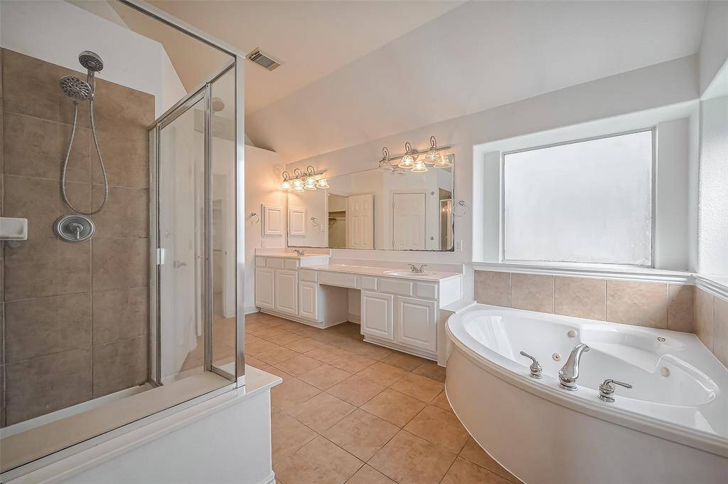 This spacious primary bathroom is the perfect place to get away and take a bath in this inviting jetted soaking tub, separate oversized shower, dual sinks and vanity.