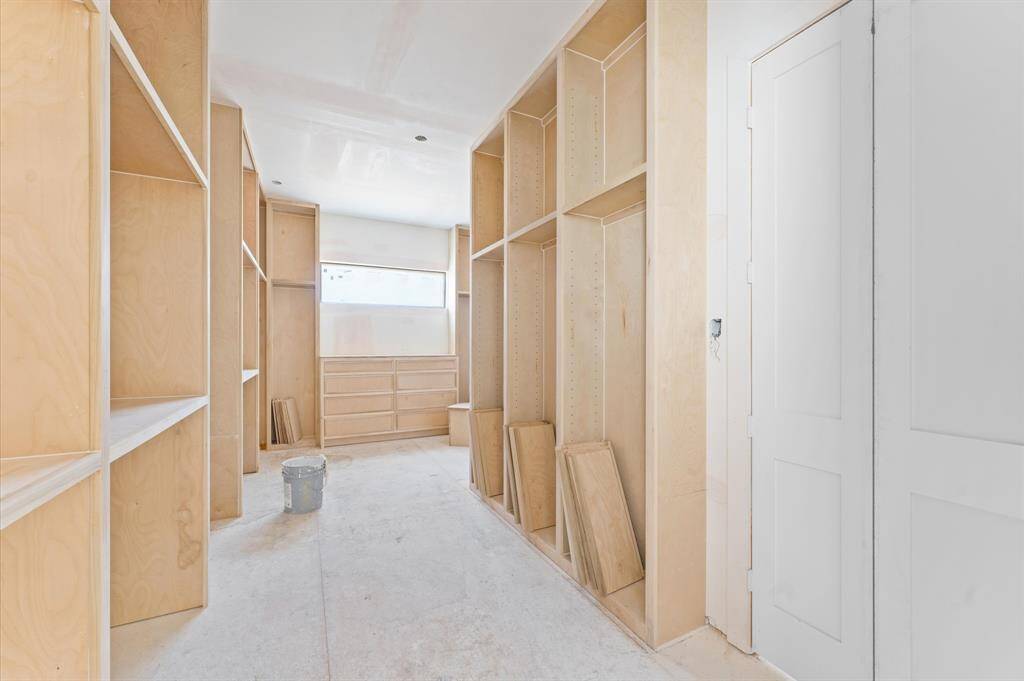 Custom oak 24 in built-in shelving enhances the oversized primary closet.