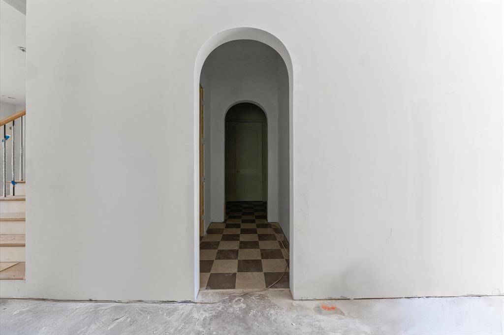 Arched doorways enhance the entry to the mudroom area with lockers.