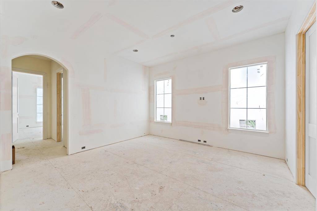 The second floor includes a large game room and bath with dual access. Striking arched doorway leads to another bedroom/bathroom.