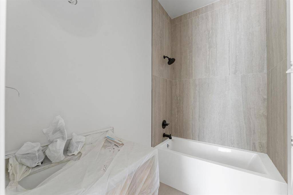Bath 3 offers custom shaker cabinets with cream tones that enhance the quartz countertops.