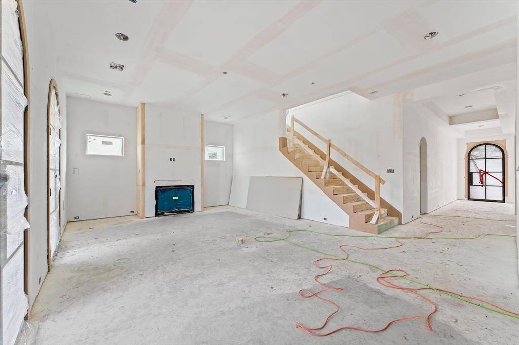 Expansive living room has gas fireplace with curved sides to mirror the kitchen vent hood.