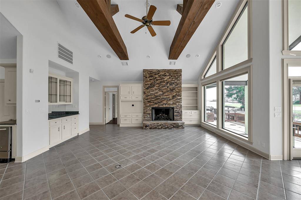 Large living room with built in bar and stone fireplace. Lots of storage cabinets in this home.