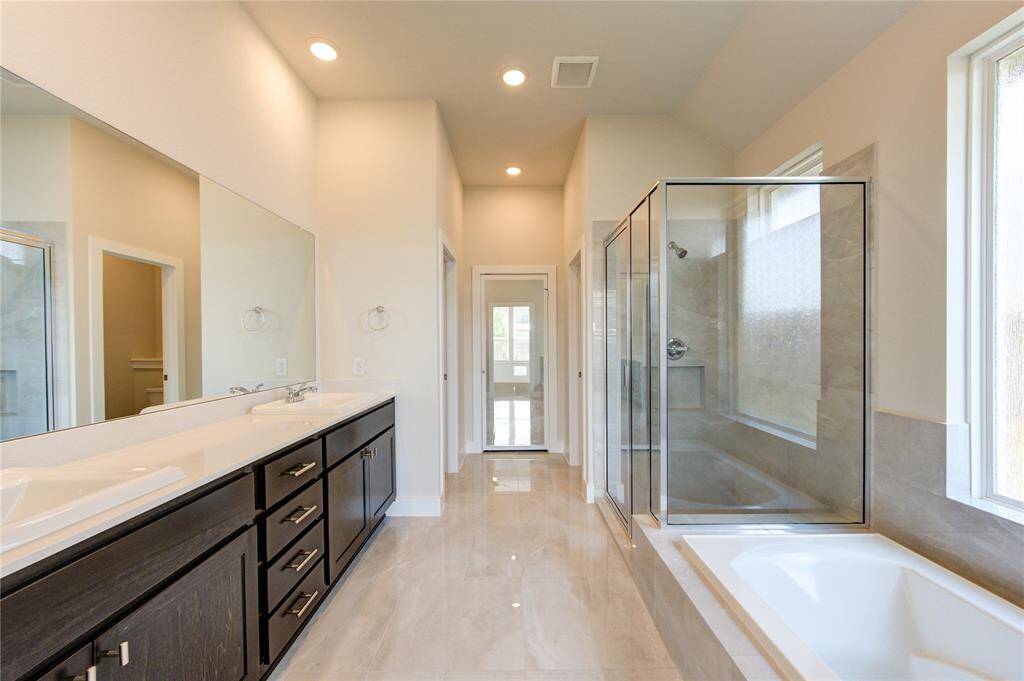 Spa like primary bathroom with double sinks, separate shower and soaking tub.