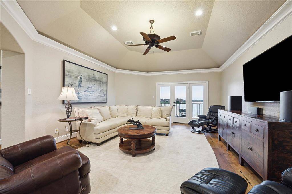 THE LARGE GAMEROOM FEATURES GAMBREL CEILINGS AND ACCESS TO A LAKEFRONT BALCONY.