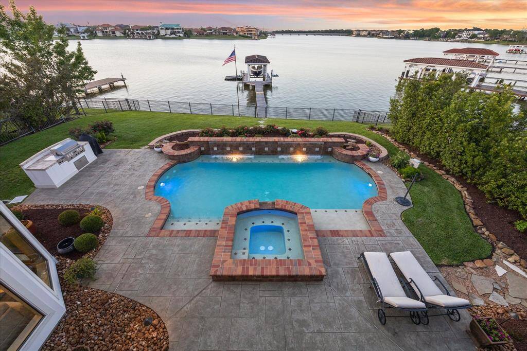 VIEW OF THE LAKE, POOL, EXTENSIVE ENTERTAINING AREA AND BOATHOUSE FROM THE BALCONY.