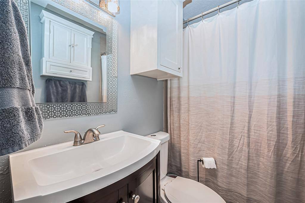 View of bathroom with updated vanity and built in linen cabinet.