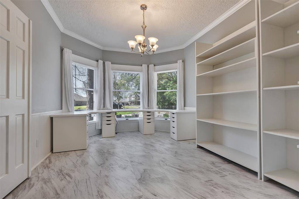 The formal dining room - currently being used as craft/hobby room, can be used however you need!  The desk and the shelving units are not attached and are easily removable, as well las the island (not shown) here.