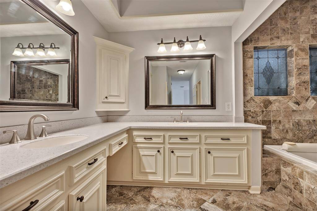 Gorgeous primary suite with double vanity area, loads of cabinets and a luxurious tile bath!
