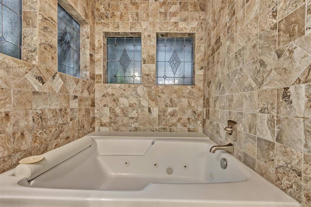 This oversized spa tub with shower is tucked into it's own nook, ready to relax you after a long day!