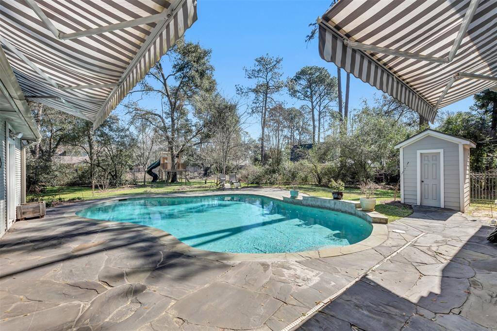Beautiful pool to relax and enjoy in our Texas heat!  Enjoy large awnings on either side to give you shade when you want it!  The pool house bath is shown on the right.  Also notice how deep the lot is!