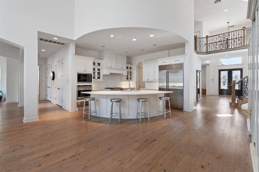 This chef's kitchen features a large island with a Sub-Zero refrigerator and Wolf appliances.