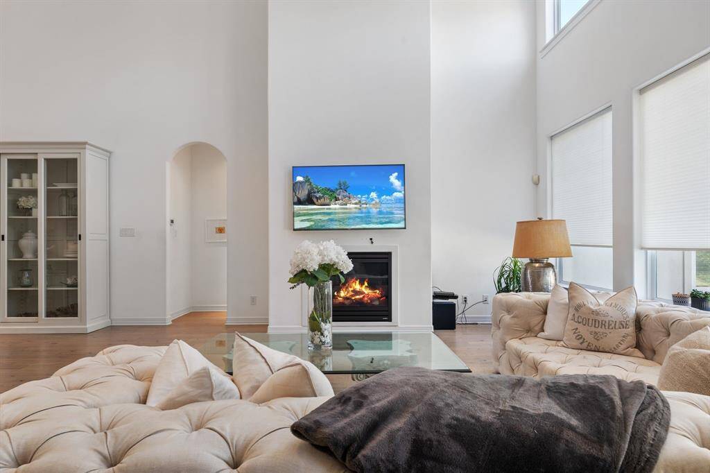 This bright and open living room has high ceilings, and features a cozy fireplace. There is large windows to provide ample natural light.
