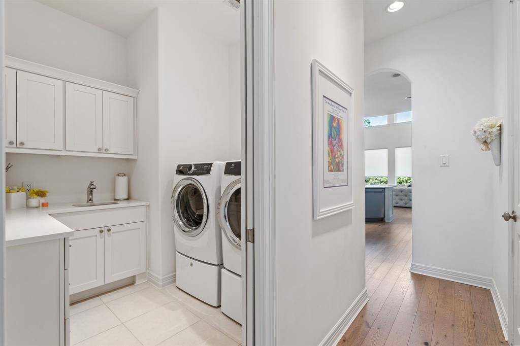 The laundry room offers cabinetry for easy storage and a utility sink!