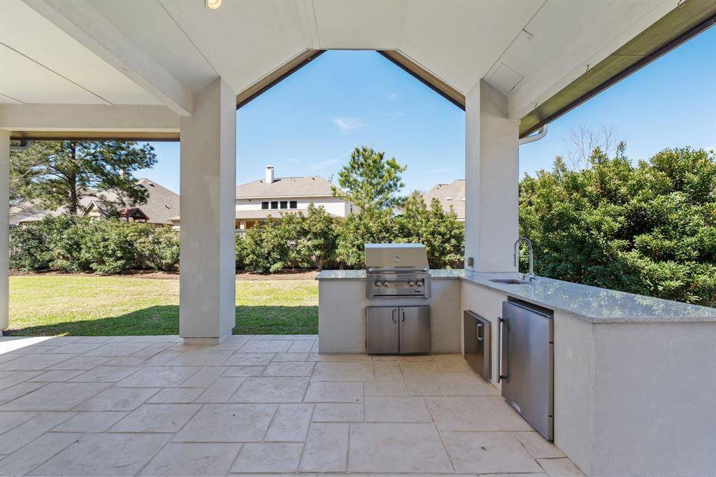Experience outdoor living at its finest with this covered patio featuring a fully equipped outdoor kitchen.