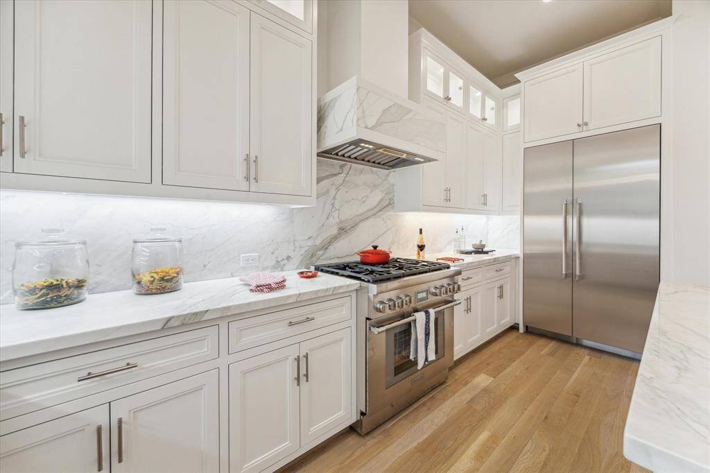 The Kitchen features marble Counters, and high end appliances including this six burner gas Range and commodious Refrigerator/Freezer.