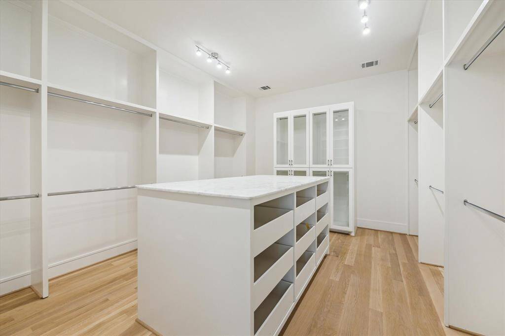 Any connoisseur of clothing will recognize closet perfecting--Here it is! The larger of the dual Closets features a wide array of sartorial storage including: Drawers, Hanging Spaces, Cupboards as well as a triple length, marble topped Packing Station.  Above are LED art lights to provide clear and precise light for you as you are making your wardrobe choices.