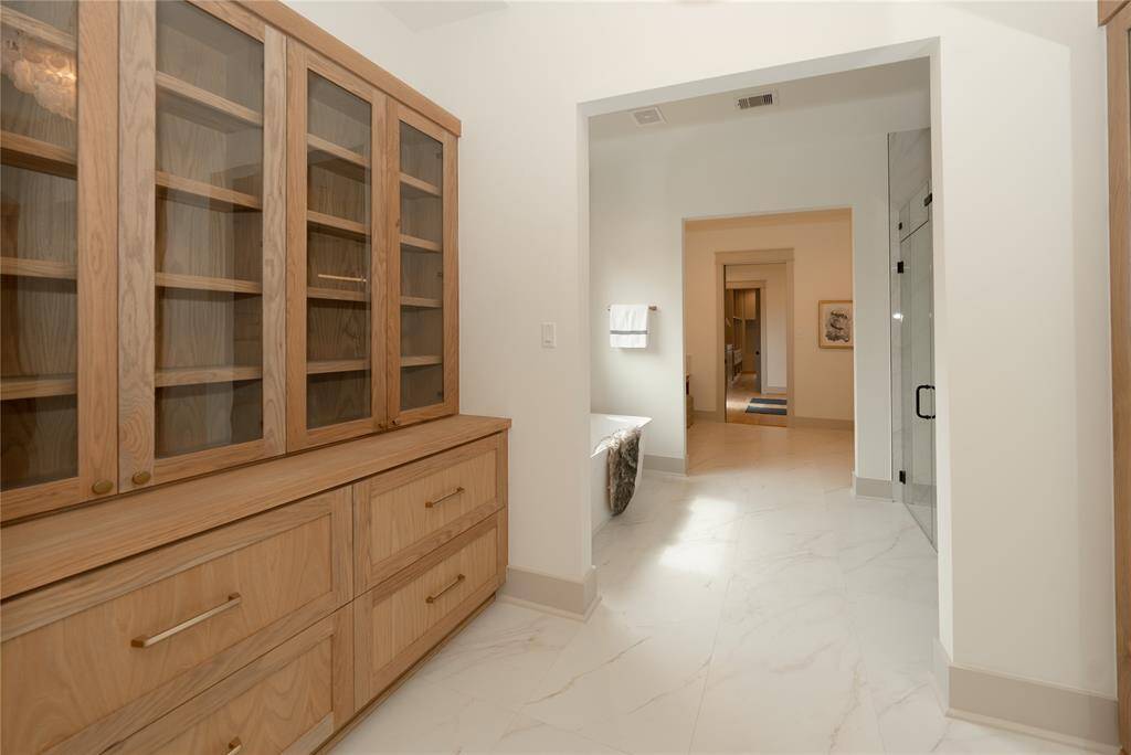 Step into your primary bath with a linen closet and mirror.