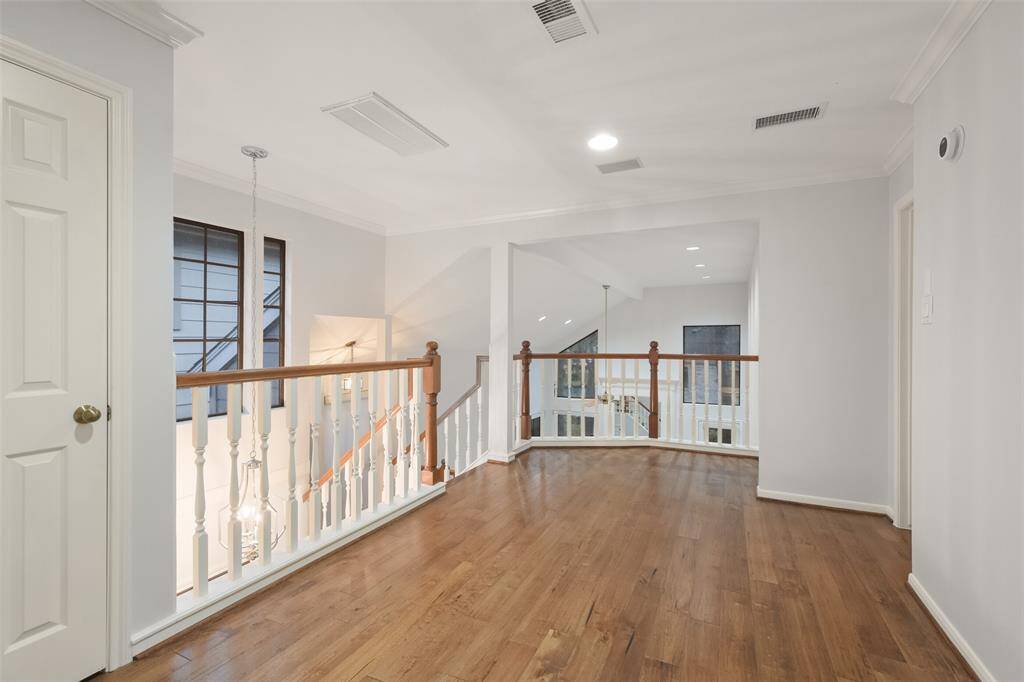 The upstairs landing, with its warm wood floors, offers a versatile space perfect for a home office, cozy reading nook, or play area.