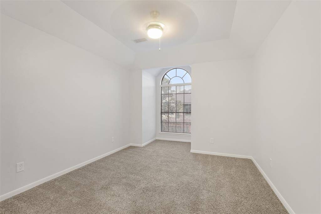 Another generously sized secondary bedroom on the second floor, featuring a charming niche window with scenic views of the front of the home.