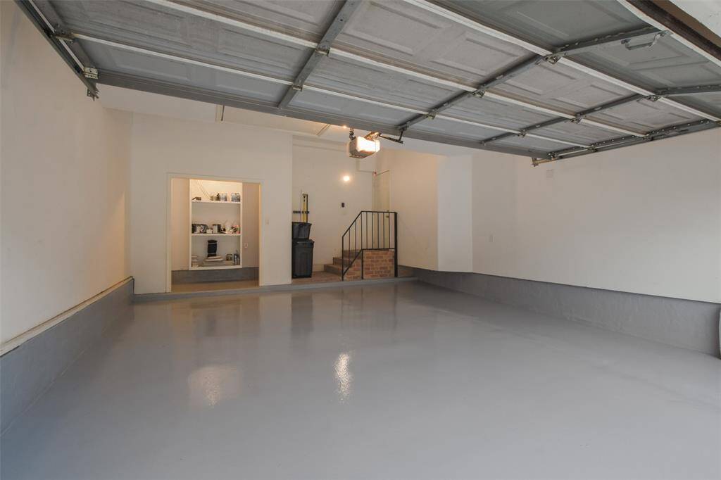 A spacious two-car garage featuring durable epoxy floors and extra storage space, perfect for organization and convenience.