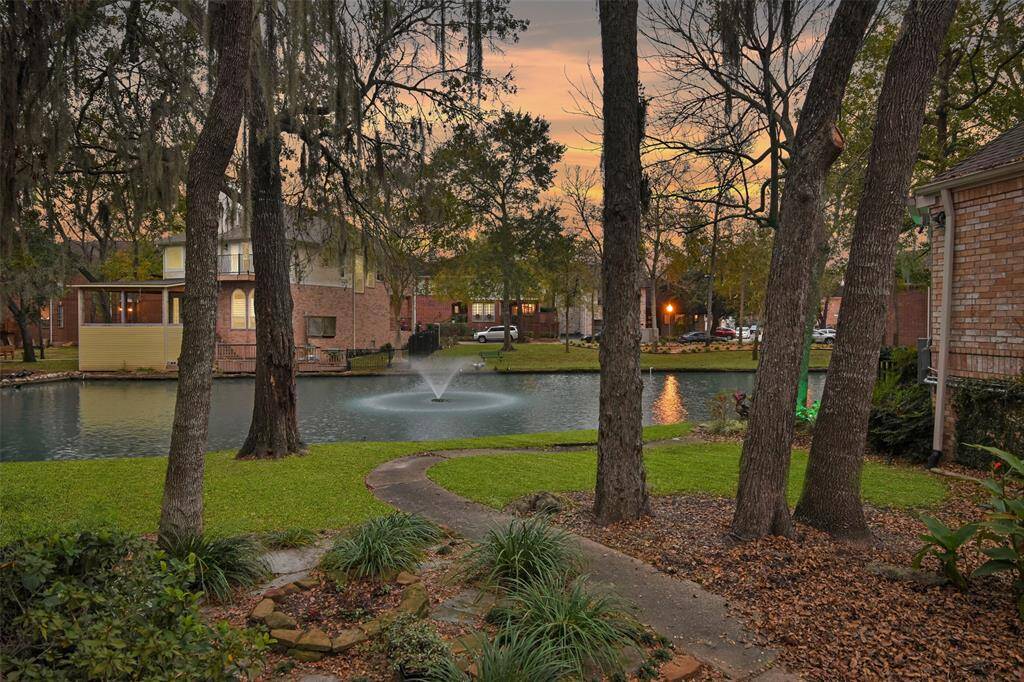 A picturesque glimpse of the community lake and fountain, featuring a charming pathway that meanders from the property to the water's edge creating a seamless connection between home and the tranquil lake.