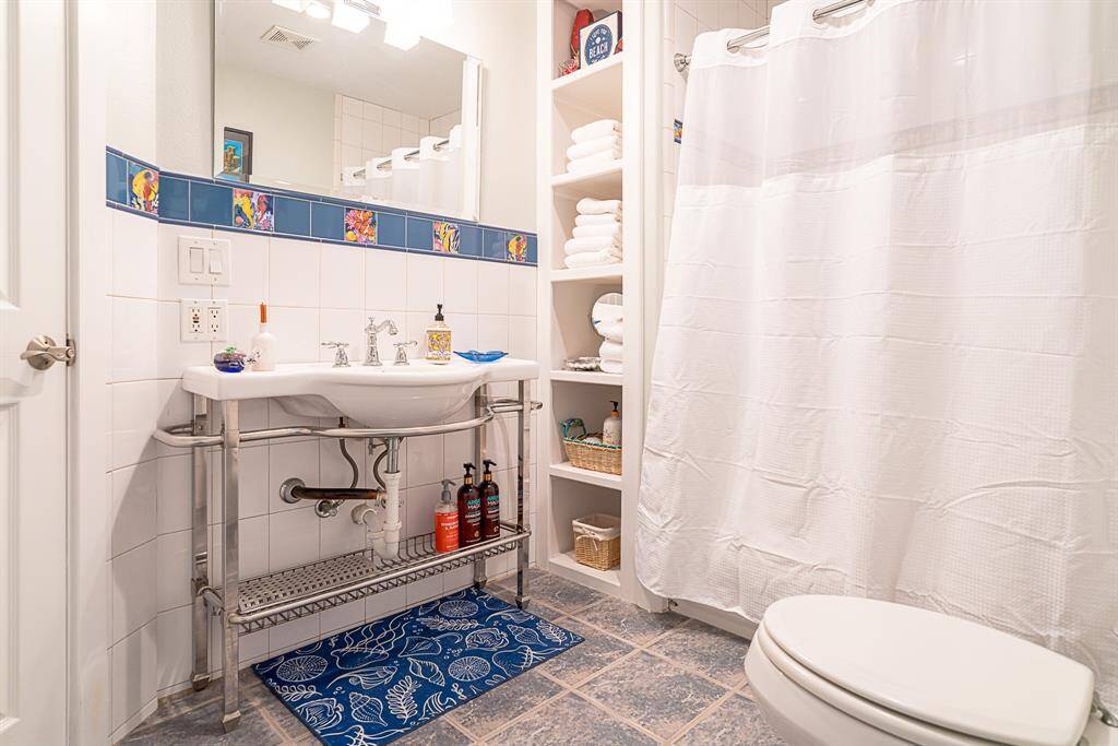 Shower & tub combo with designer tiles in bathroom