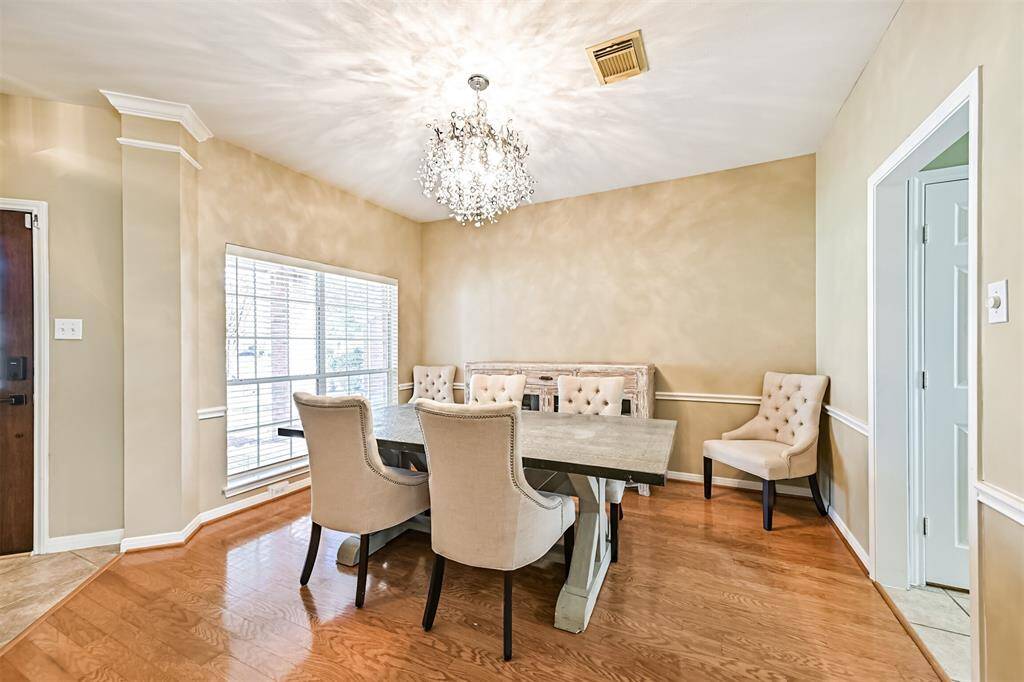 The formal dining room opens to the kitchen for easy access. Designer chandelier and windows provide ample natural light.