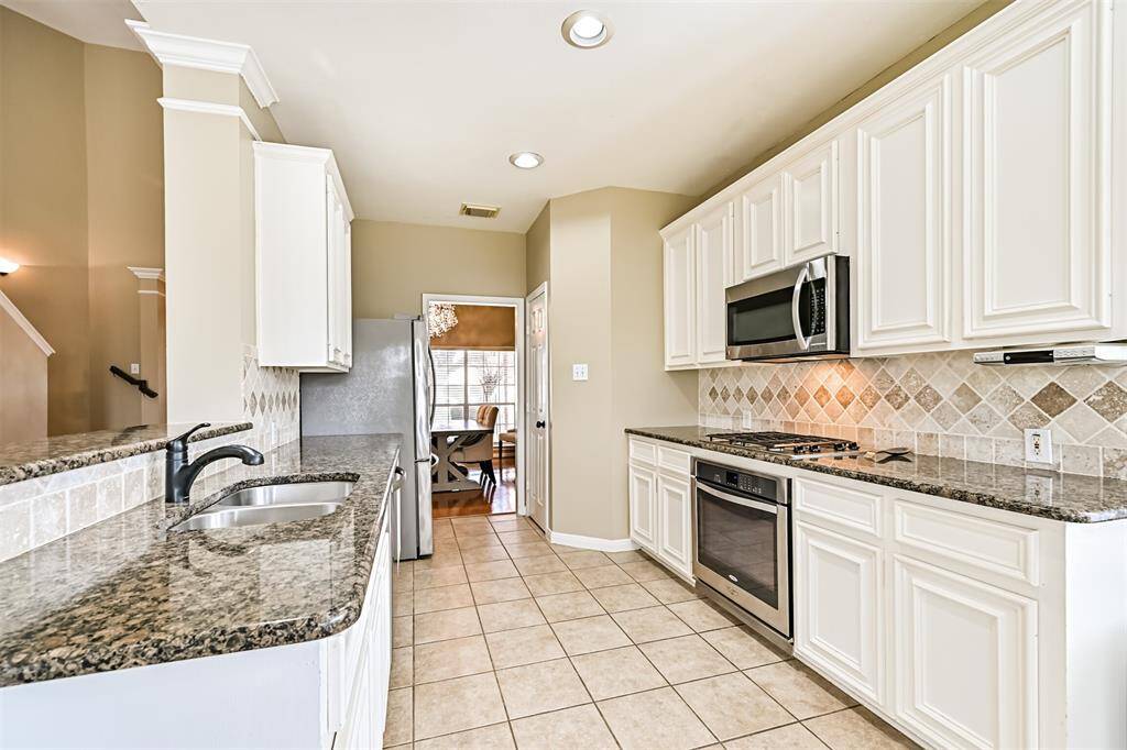 The kitchen features granite counters, stainless steel appliances, gas cooktop and microwave. Refrigerator is included.
