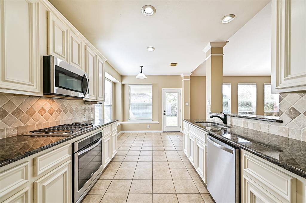 Entrance to the kitchen from the formal dining room. Opens to the living room and breakfast space to the rear.