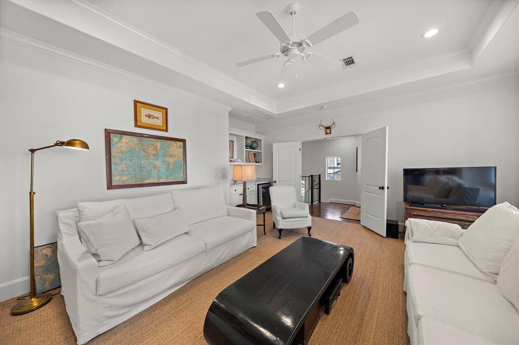 Upstairs the family room offers a spacious retreat complete with a tray ceiling, plantation shutters, and wall of built-ins to showcase your favorite decor.