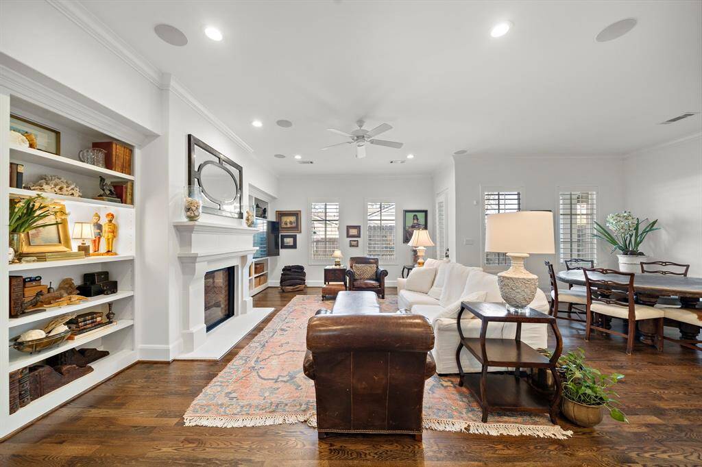 The spacious living area opens to the dining space. Beautiful hardwood floors, high ceilings, and striking cast stone fireplace add warmth and sophistication to the space.