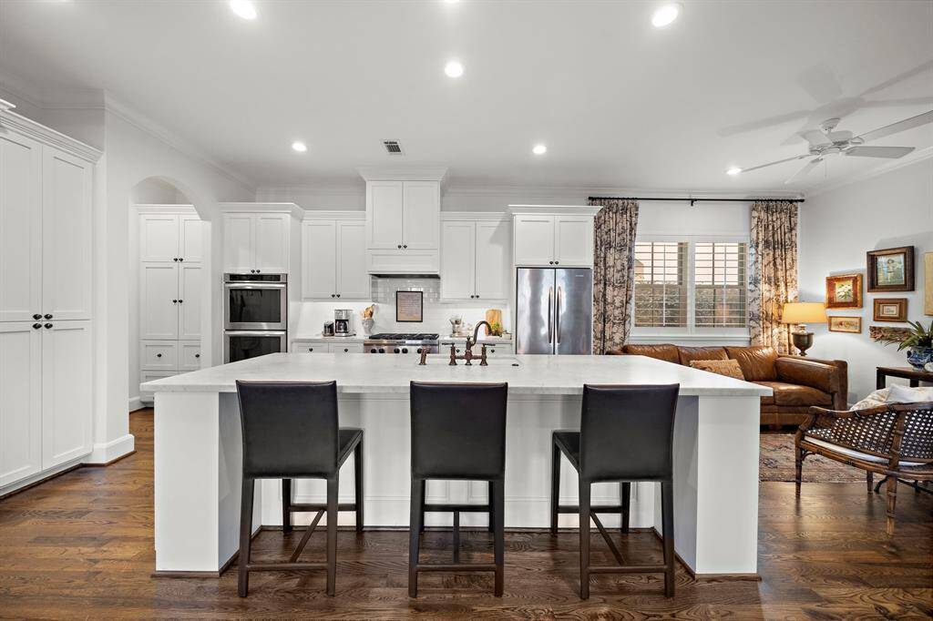 This island kitchen is a chef's dream, complete with double ovens, custom cabinetry, and ample counter space.