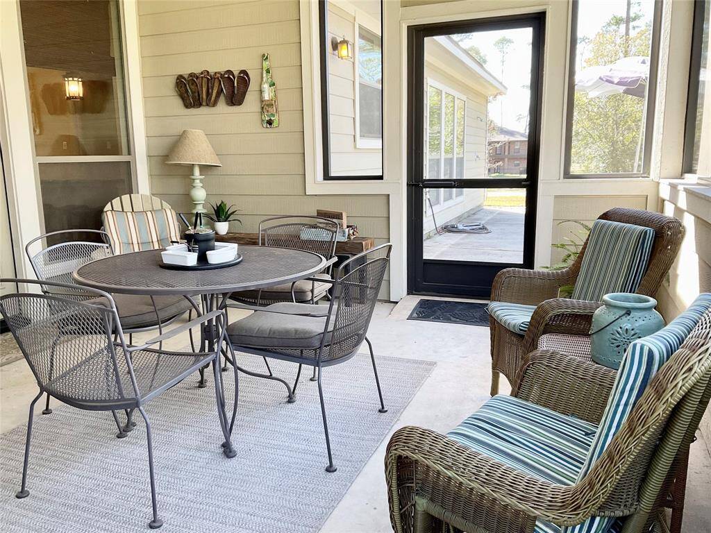 This cozy outdoor patio features a charming stone, wood burning fireplace, comfortable wicker seating, and a round table with metal chairs, offering a perfect space for relaxation and entertaining.  The furnishings can remain or be removed as you desire.