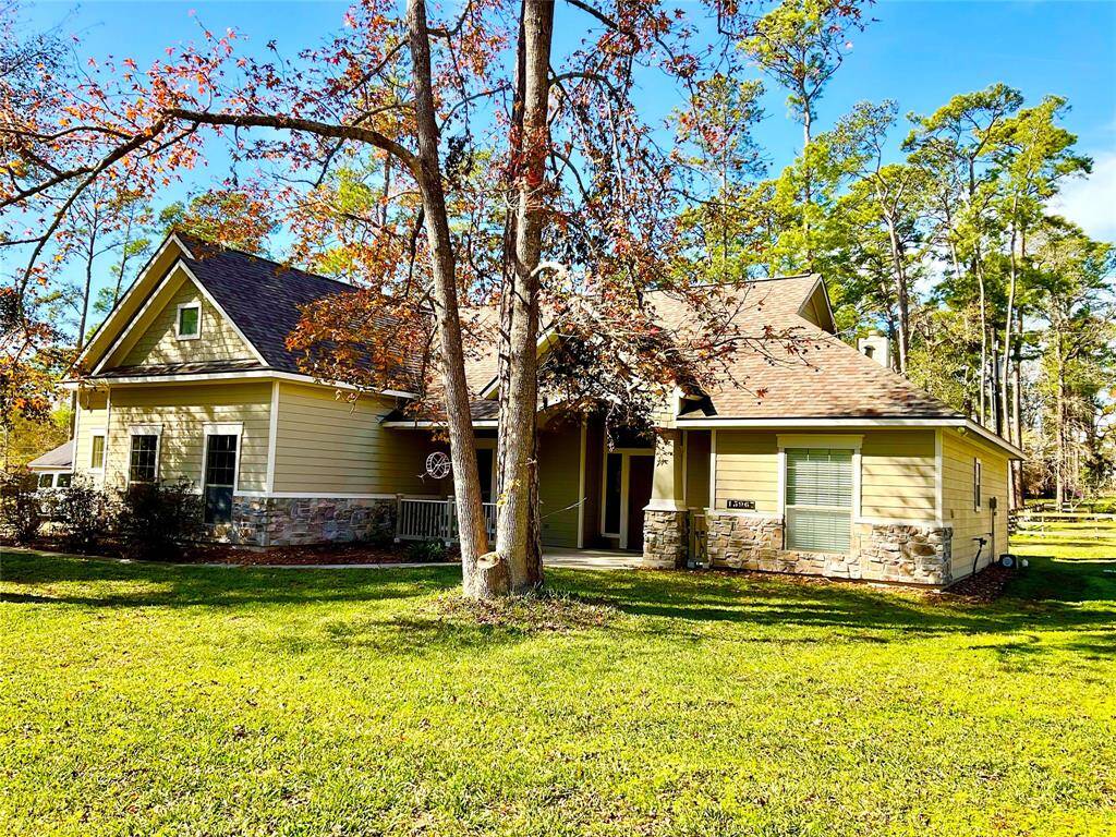 Charming single-story home with a mix of stone and siding exterior, nestled among trees. Features a spacious front yard and a cozy porch, offering a serene, natural setting. Ideal for those seeking a peaceful retreat.