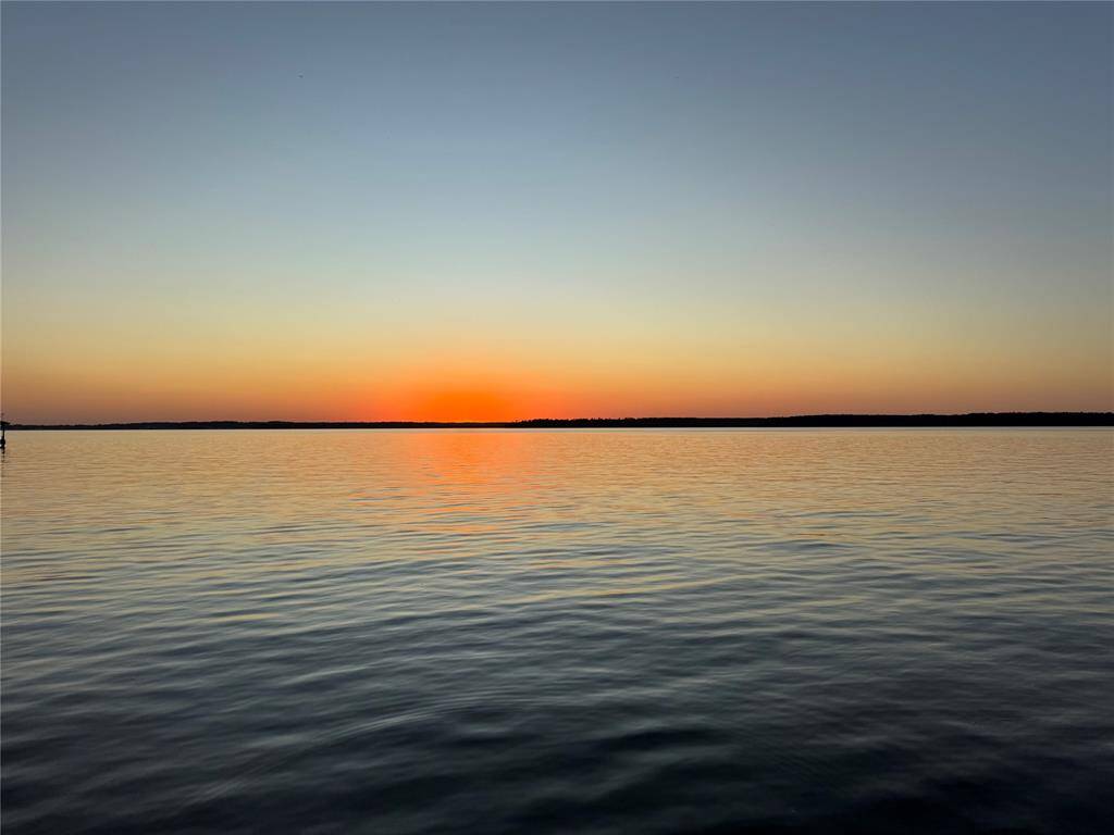 Stunning sunset views over a calm lake visible from the neighborhood community center.  The vibrant hues of orange and gold reflecting on the water, create serene and picturesque views, for your enjoyment.