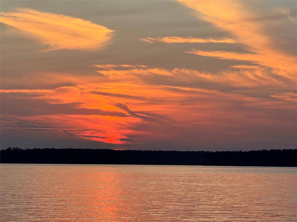 Stunning sunset views over a calm lake visible from the neighborhood community center.  The vibrant hues of orange and gold reflecting on the water, create serene and picturesque views, for your enjoyment.