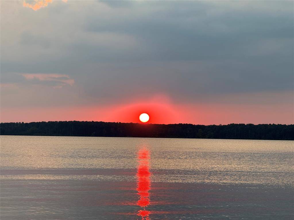 Stunning sunset views over a calm lake visible from the neighborhood community center.  The vibrant hues of orange and gold reflecting on the water, create serene and picturesque views, for your enjoyment.