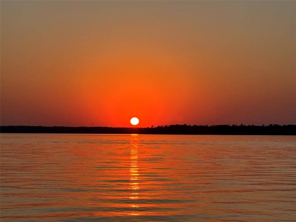 Stunning sunset views over a calm lake visible from the neighborhood community center.  The vibrant hues of orange and gold reflecting on the water, create serene and picturesque views, for your enjoyment.