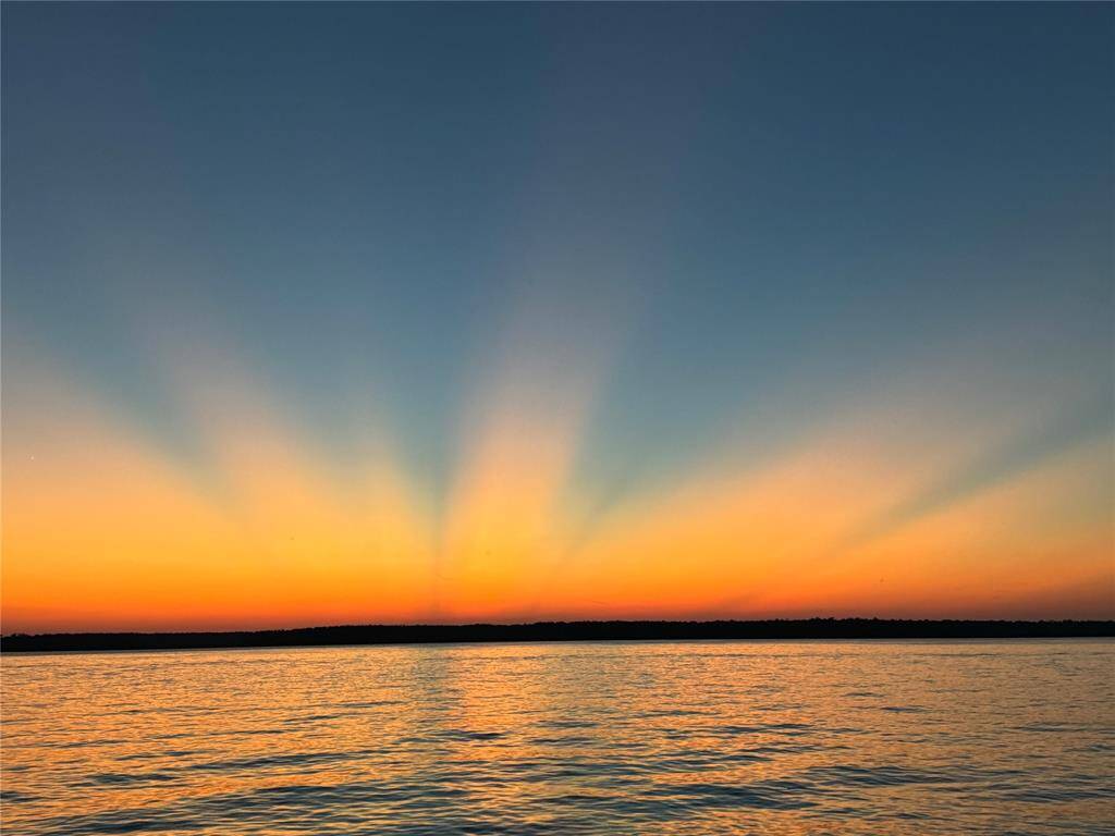 Stunning sunset views over a calm lake visible from the neighborhood community center.  The vibrant hues of orange and gold reflecting on the water, create serene and picturesque views, for your enjoyment.