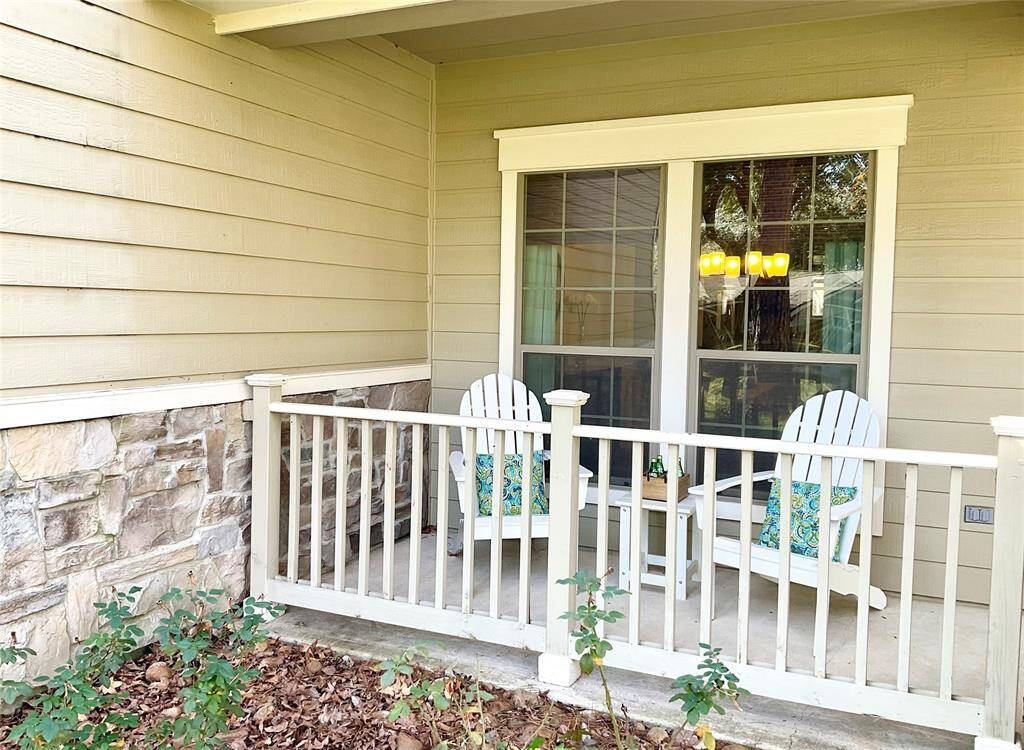 This cozy patio features two Adirondack chairs with colorful cushions, a small table, and a charming railing. It offers a welcoming outdoor space, perfect for relaxation and enjoying the fresh air. The siding and stone accents add a warm, inviting touch.