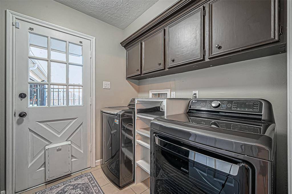 Spacious laundry room with abundant cabinet storage.