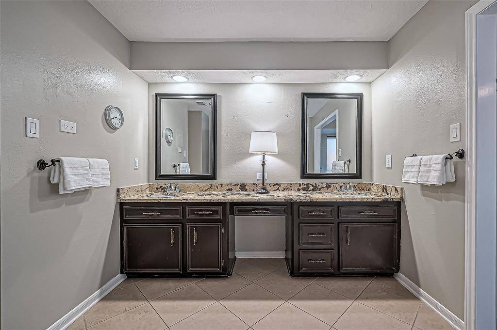 Luxurious primary bathroom with dual vanities and ample cabinet storage.